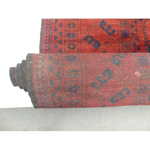 654 - Vintage Afghan tribal wool rug with a deep red field and navy blue accents, featuring a repeating oc... 