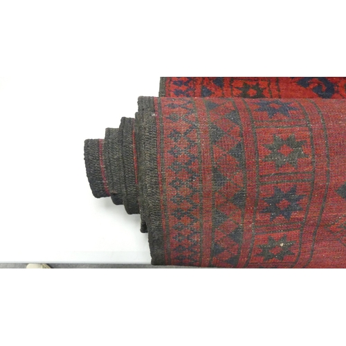 654 - Vintage Afghan tribal wool rug with a deep red field and navy blue accents, featuring a repeating oc... 