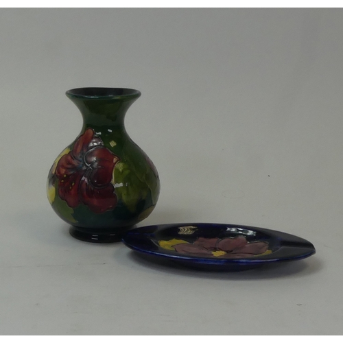 89 - Moorcroft Hibiscus pattern vase on green ground, together with Hibiscus dish on dark blue ground. (H... 