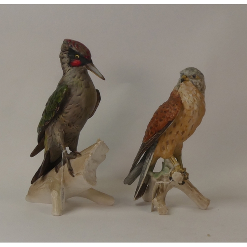 103 - Goebel porcelain figurines to include green woodpecker perched on a log, and falcon, perched on a tr... 