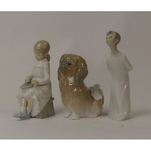 96 - Lladró porcelain figurine, Pekinese Sitting, together with two NAO porcelain figurines, Boy Kissing ... 