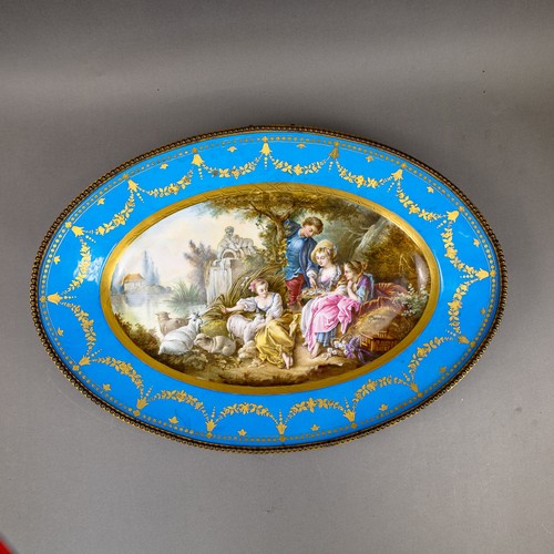 36 - A large oval dish ornately decorated in the manner of Sevres porcelain, featuring a male and three f... 