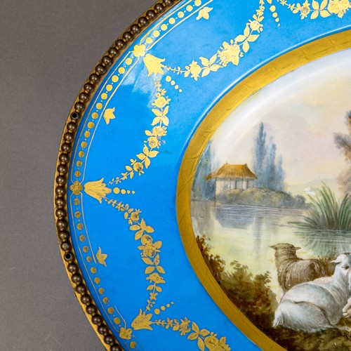 36 - A large oval dish ornately decorated in the manner of Sevres porcelain, featuring a male and three f... 