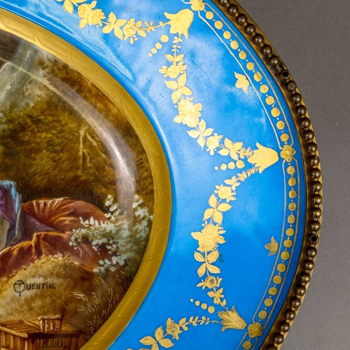 36 - A large oval dish ornately decorated in the manner of Sevres porcelain, featuring a male and three f... 