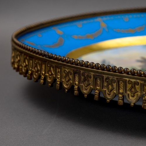 36 - A large oval dish ornately decorated in the manner of Sevres porcelain, featuring a male and three f... 
