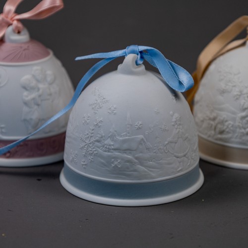 A group of five Lladro bells with ribbons, various embossed deigns ...