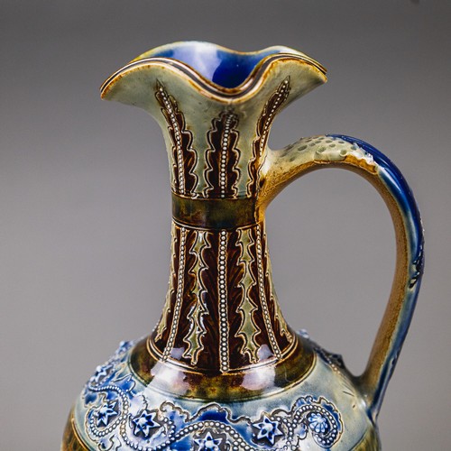 A large Doulton Lambeth ewer with a looped handle and shaped rim by ...