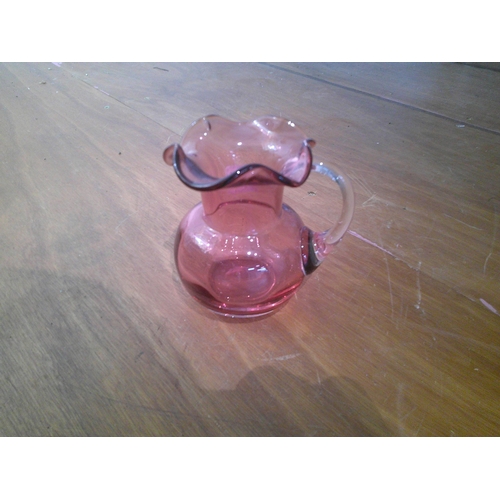 77 - Small cranberry glass jug 10cmH