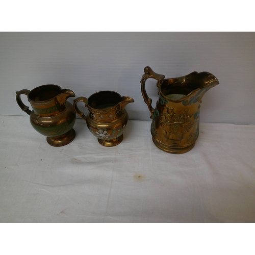 127 - Three brown lustre jugs, tallest 19cm