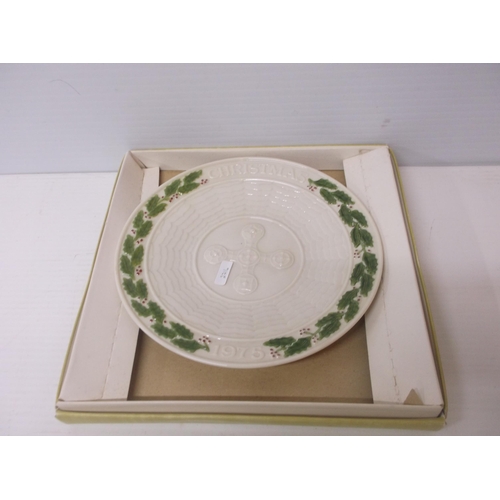 395 - A 6th period Belleek Christmas plate with holly decoration and a cross 22.5cmD