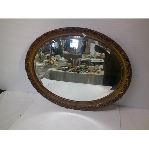 187 - An oval gilt framed bevelled edge mirror - 69cm x 53cm