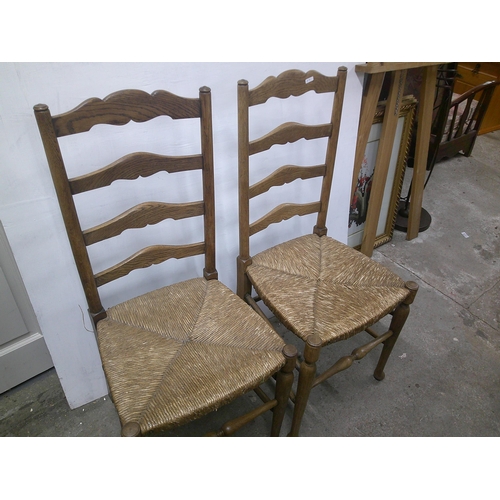 339 - A pair of ash ladder back chairs with woven seats