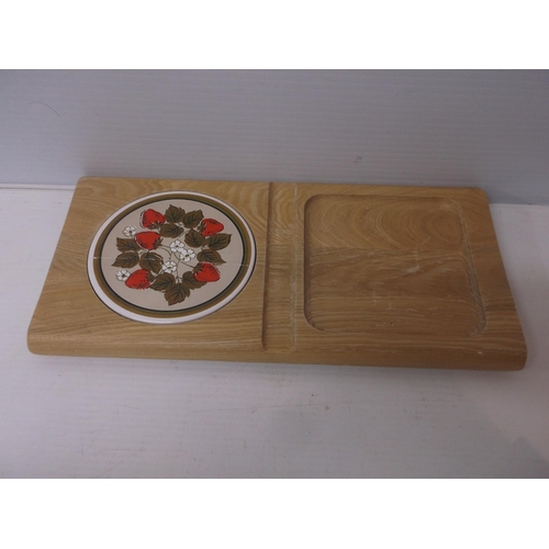 402 - A pine chopping board with ceramic plate, damaged 41cm X 20cm