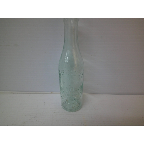 252 - A glass bottle C J Hassett, Ennis - 23cmH