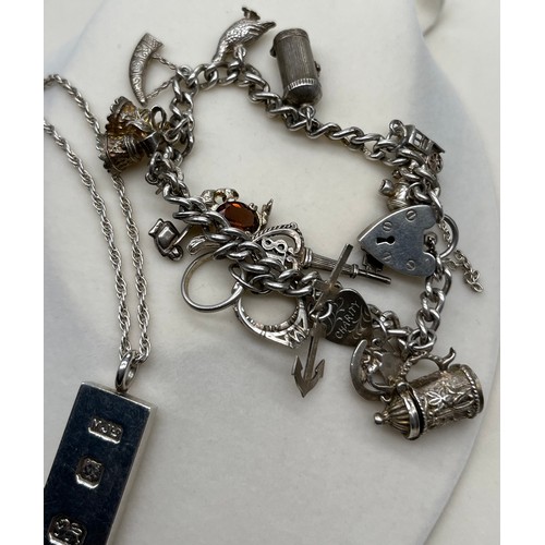 6 - Silver charm bracelet with various silver charms, Together with a heavy London silver ingot and silv... 