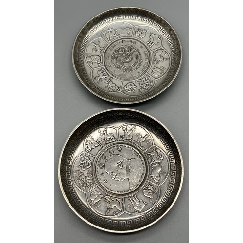 9 - Pair of White metal Chinese Zodiac dishes fitted with coins to the centre. [9cm diameter]