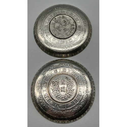 9 - Pair of White metal Chinese Zodiac dishes fitted with coins to the centre. [9cm diameter]