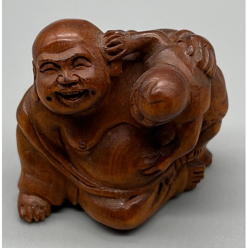 60 - Japanese hand carved netsuke; Laughing Buddha and child. Signed to the base. [3.5cm high]