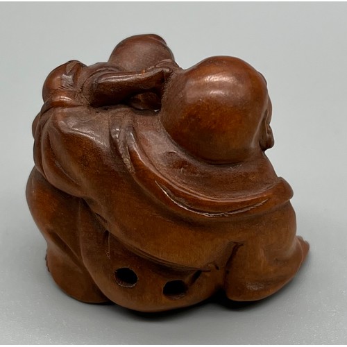 60 - Japanese hand carved netsuke; Laughing Buddha and child. Signed to the base. [3.5cm high]