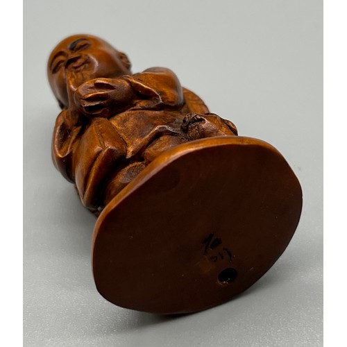 80 - Japanese hand carved netsuke; Praying figure with dog at his foot. Signed to the base. [5cm high]