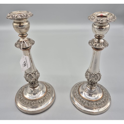 130 - A Pair of 19th century silver plate on copper candle sticks. Raised relief trims. [29cm high]