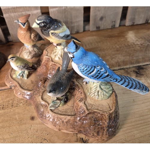 417 - Beswick and Royal Doulton tree stump stand with various Beswick bird figures.