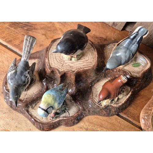 417 - Beswick and Royal Doulton tree stump stand with various Beswick bird figures.