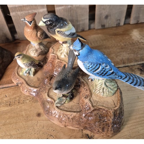 417 - Beswick and Royal Doulton tree stump stand with various Beswick bird figures.