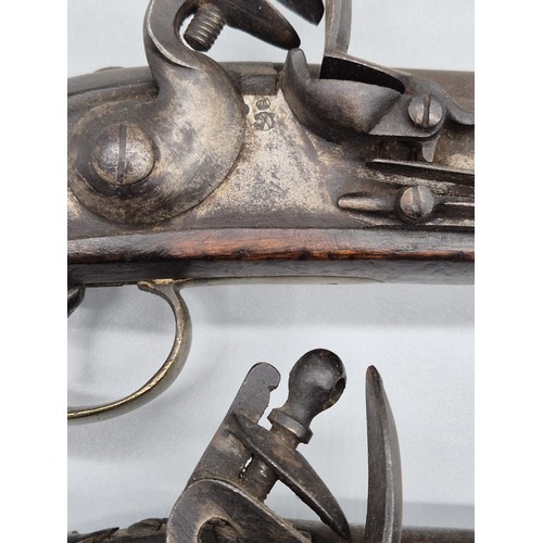 183 - A Pair of 19th century East Indian Company flint lock pistols. Mahogany bodies, Steel and brass fitm... 