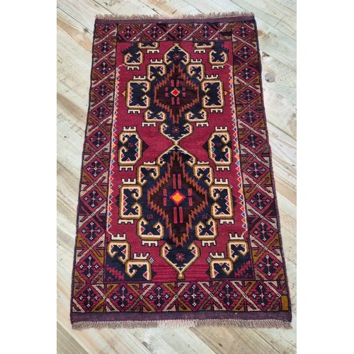 340 - Hand made Baluchi red ground rug. [146x83cm]