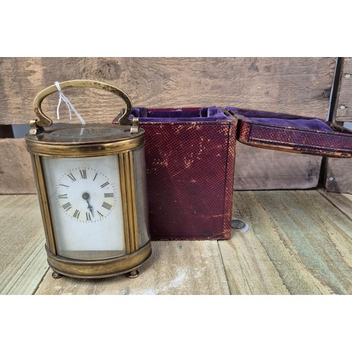 390 - Antique French single barrel brass and bevel glass carriage clock. Comes with leather travel case.