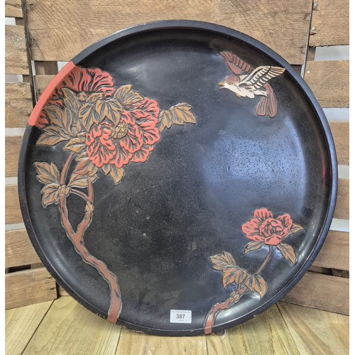 387 - A Large Chinese lacquered, painted and hand carved wooden wall charger. [52.5cm diameter]