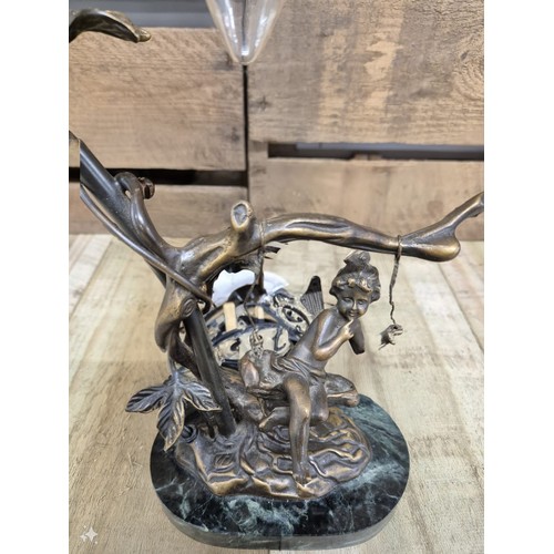 165 - Bronze table lamp sculpture, child on a swing. Raised on a marble base.