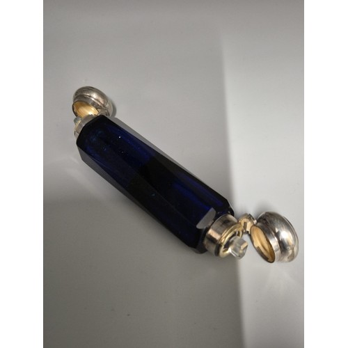 77 - 19th century cobalt blue cut glass double sided perfume bottle, fitted with white metal lids and com... 