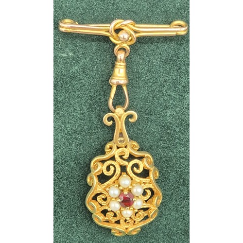 129 - Victorian 9ct yellow gold ornate hanging brooch. Set with a round cut garnet and surrounded by pearl... 