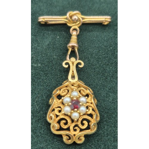 129 - Victorian 9ct yellow gold ornate hanging brooch. Set with a round cut garnet and surrounded by pearl... 