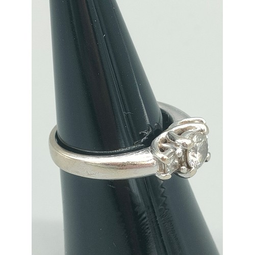 34 - A Tiffany inspired 14ct white gold and diamond set ring. Centre round cut diamond [0.50ct] off set w... 