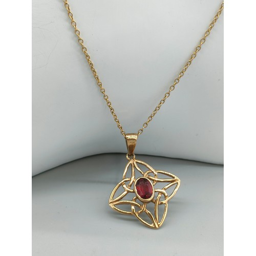 32 - 9ct yellow gold Celtic design pendant fitted with an oval cut Garnet gem stone, comes with a 9ct yel... 