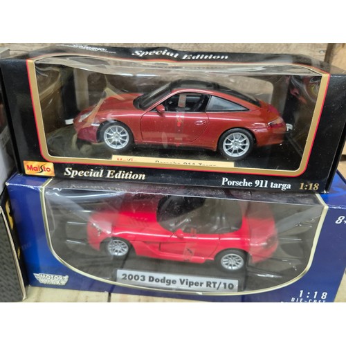 312 - A collection of four various 1.18 scale models; Ford Escorts Bosworth, Renault sport clip, 2003 dodg... 