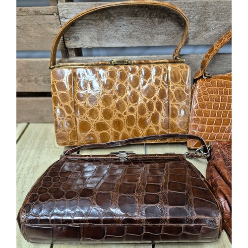 119 - Four various vintage crocodile leather hand bags; One fitted with Brass Initials and locks, Reid & T... 