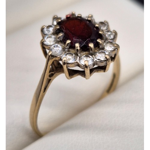 11 - Birmingham 9ct yellow gold ring fitted with an oval cut garnet gem stone surrounded by CZ Stones. [R... 