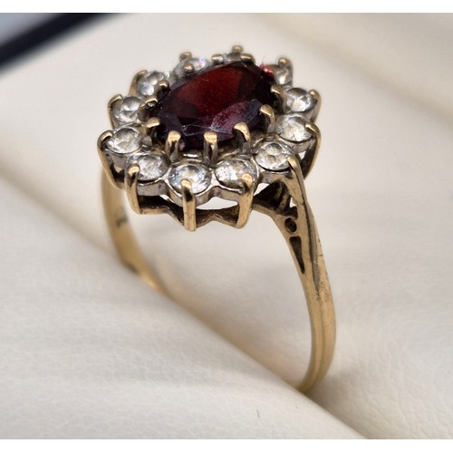 11 - Birmingham 9ct yellow gold ring fitted with an oval cut garnet gem stone surrounded by CZ Stones. [R... 