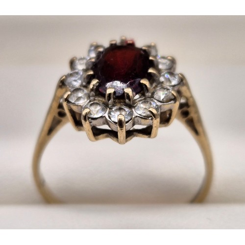 11 - Birmingham 9ct yellow gold ring fitted with an oval cut garnet gem stone surrounded by CZ Stones. [R... 