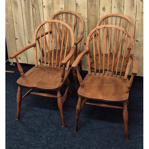 225 - A Set of four elm wood 19th century Windsor spindle back dining room arm chairs, raised on turned le... 