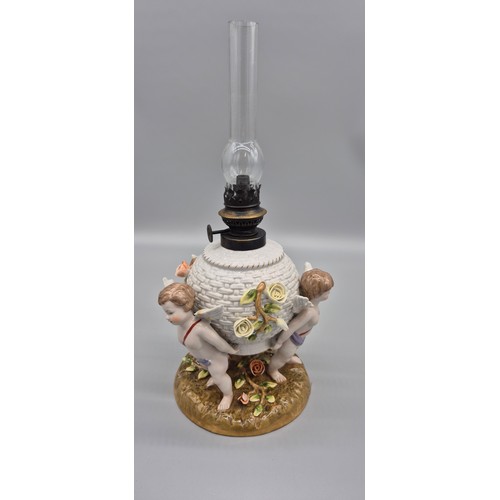 166 - 19th century German porcelain Meissen oil lamp raised on cherub figural base, comes with a glass fun... 