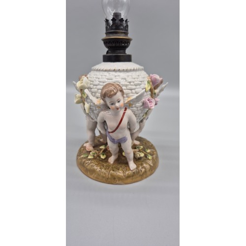 166 - 19th century German porcelain Meissen oil lamp raised on cherub figural base, comes with a glass fun... 