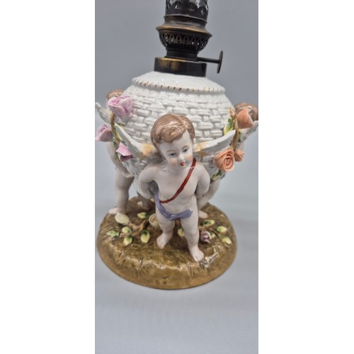 166 - 19th century German porcelain Meissen oil lamp raised on cherub figural base, comes with a glass fun... 