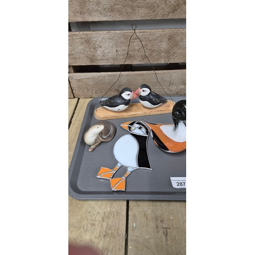 287 - A Tray of collectables; puffin figures, art glass plaque, puffin plaque & other items