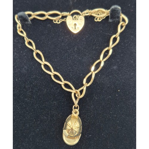 7 - 9ct yellow gold bracelet fitted with cap charm and heart lock. [9.08grams]