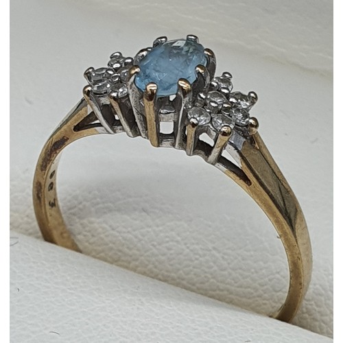 18 - 9ct yellow gold ring fitted with an oval cut aquamarine gemstone and diamond cluster. [Ring size R] ... 